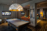Sun Chandelier Gold 140, in hotel game room, light over pool table, 