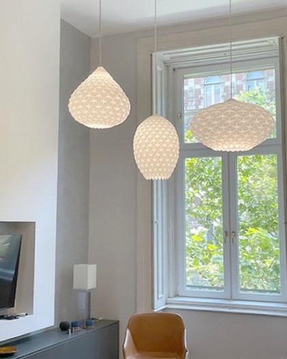 Three unique Hexa pendant lights suspended in a living room, providing soft, ambient lighting with a modern aesthetic.