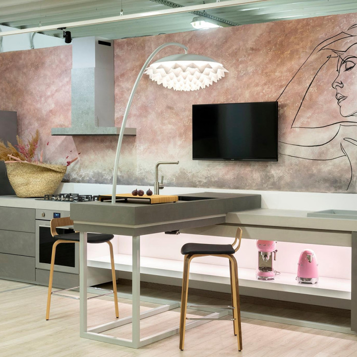 A modern kitchen featuring a large island and a vibrant wall mural, illuminated by elegant Flora pendant lamps with floral designs.